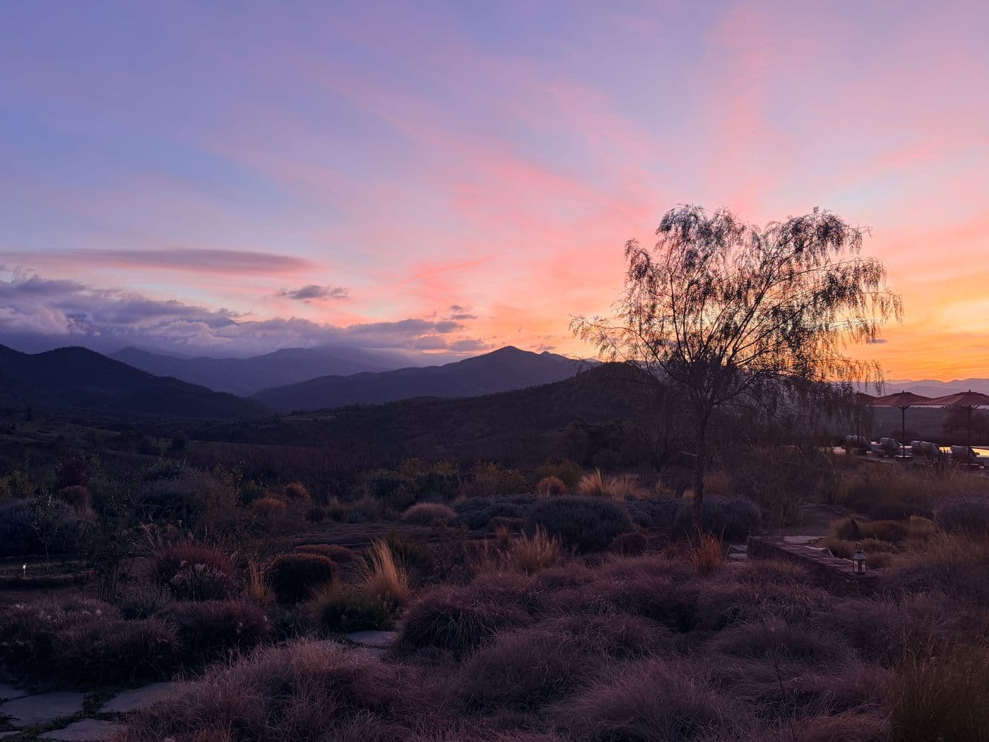 Coucher de soleil sur le domaine privé Eladâr, près de Marrakech, dans une atmosphère chaleureuse propice aux célébrations face à l’Atlas.
