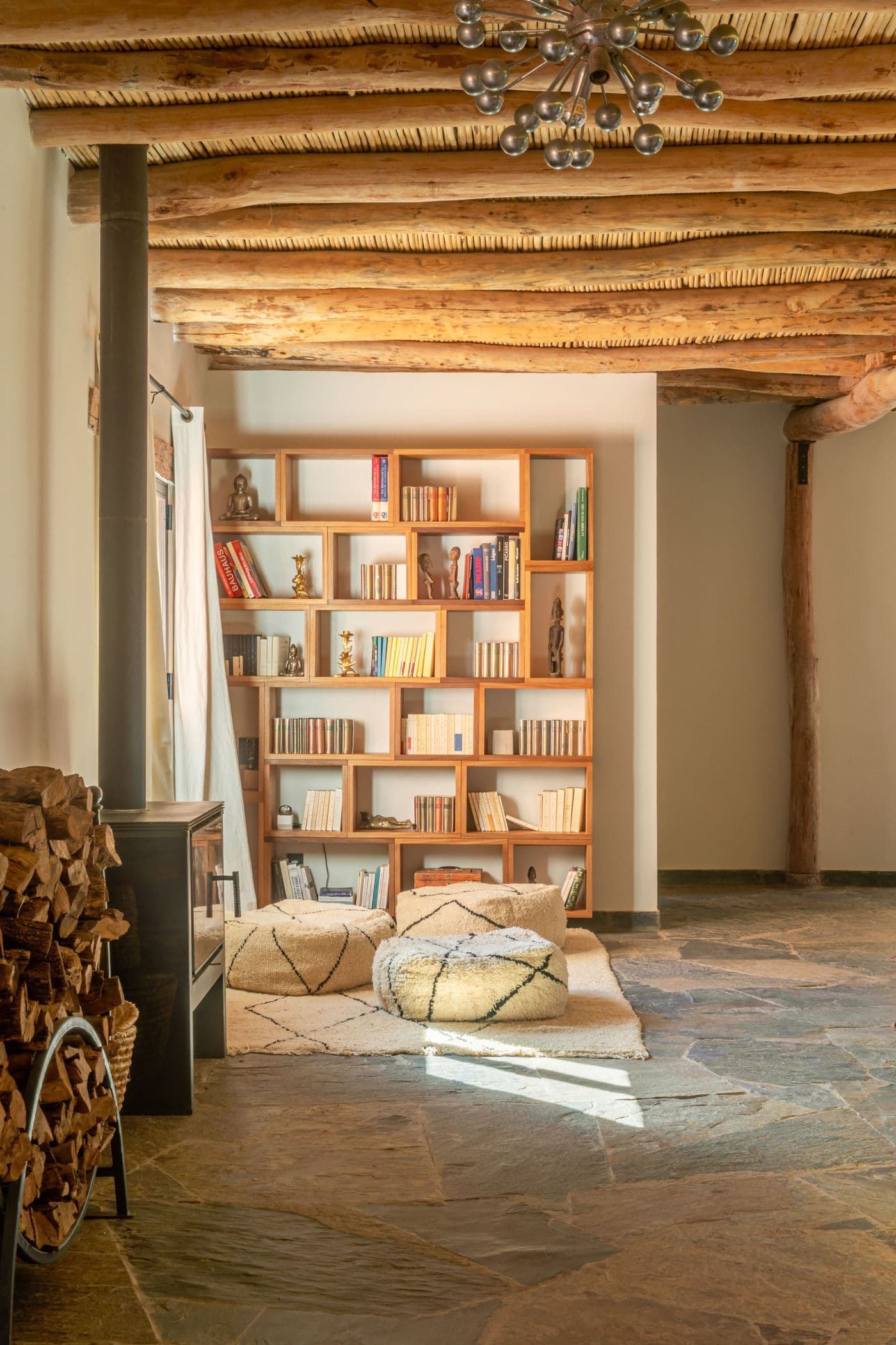 Salon-bibliothèque avec un poêle à bois au Domaine Eladâr