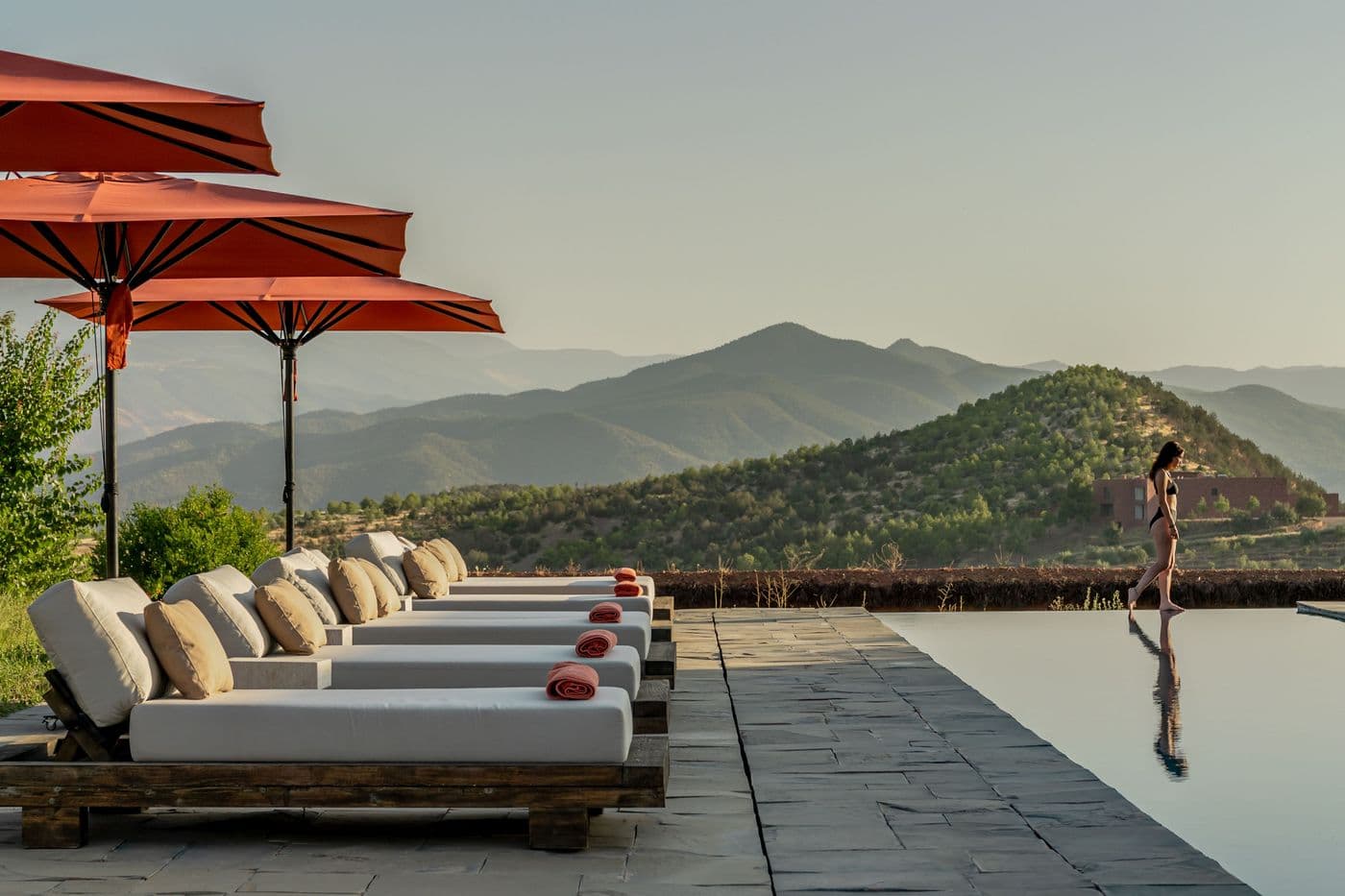Piscine, transats et modèle avec vue sur l’Atlas au Domaine Eladâr