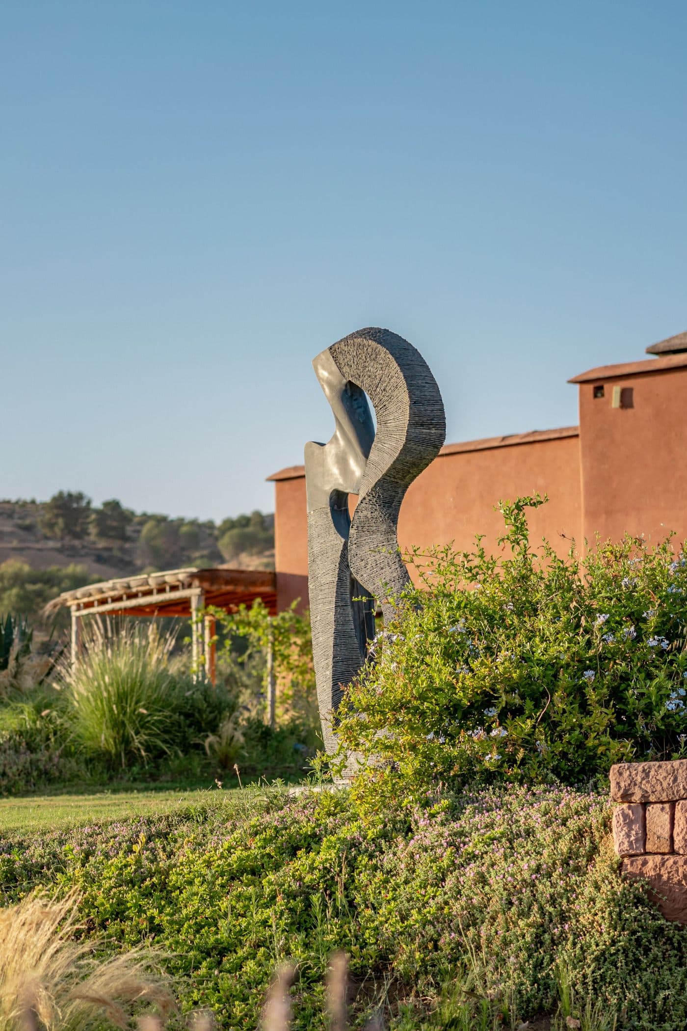 Sculpture dans le jardin devant la façade d’une suite au Domaine Eladâr