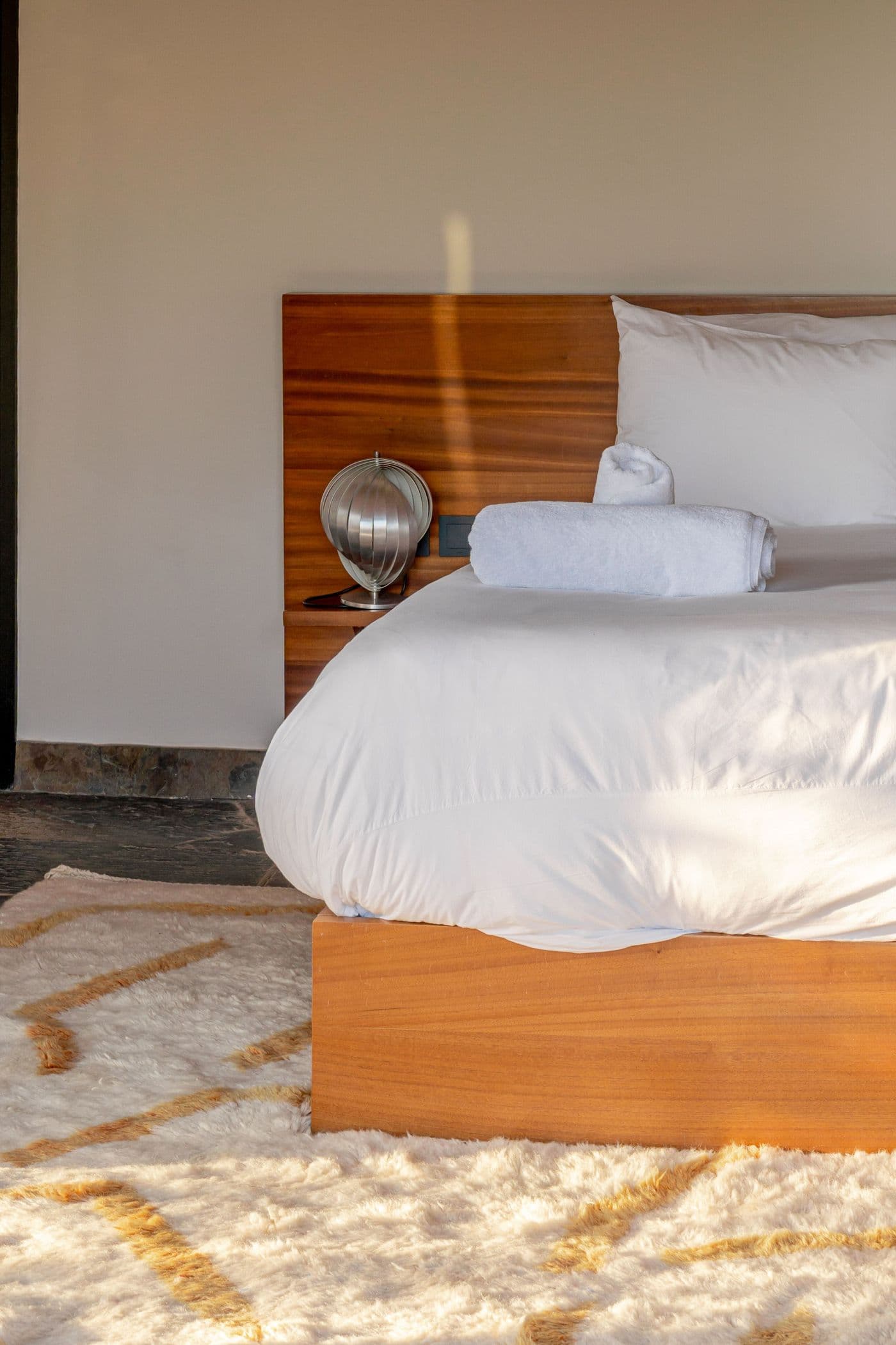 Détail du lit et du tapis d’une suite au Domaine Eladâr