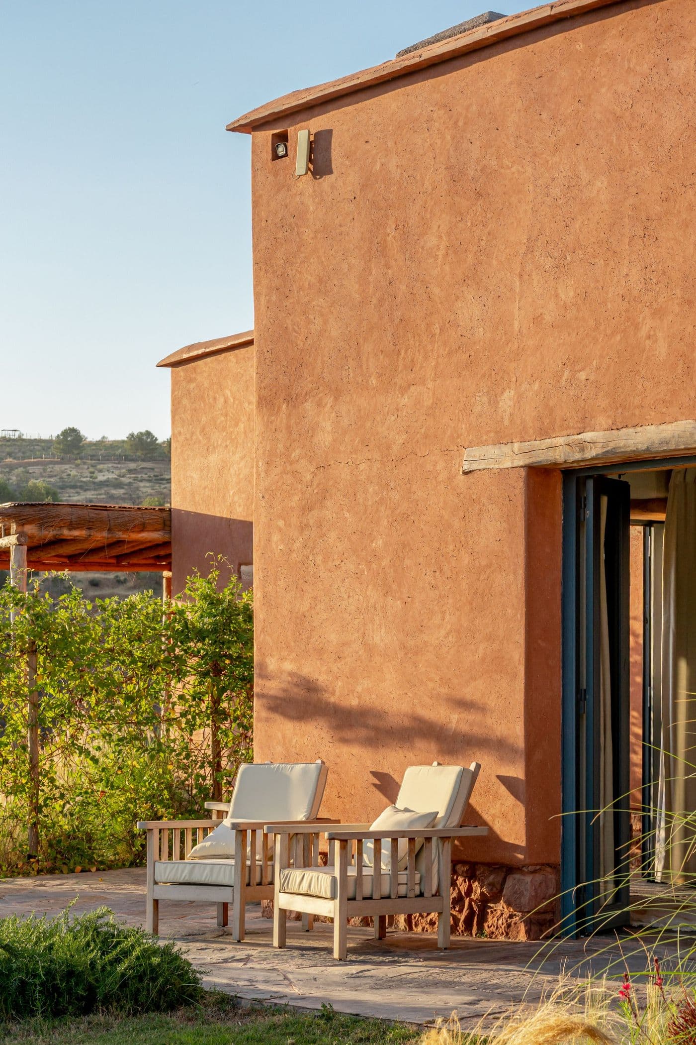 Fauteuils sur la terrasse d’une suite devant la façade au Domaine Eladâr