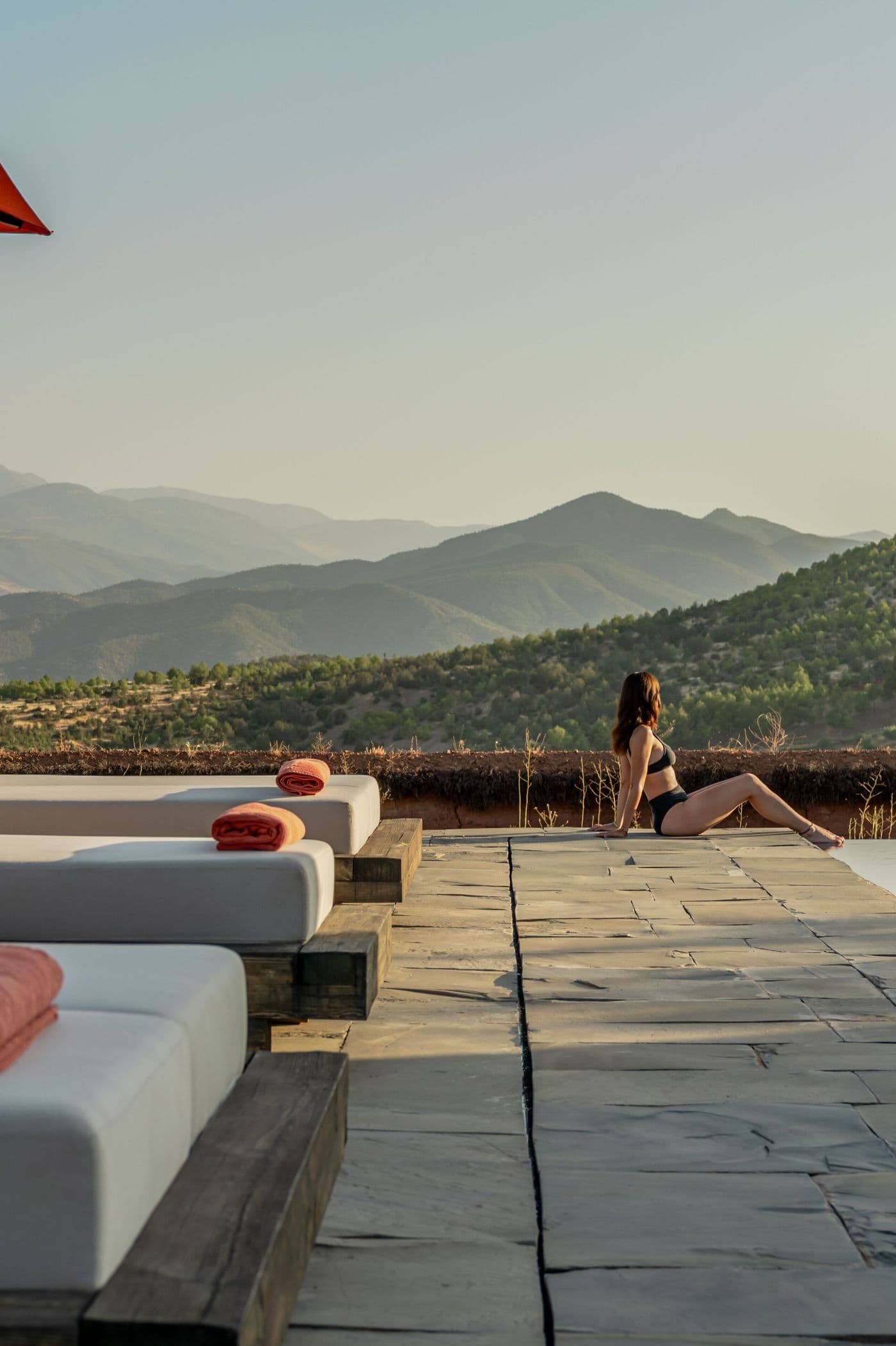 Transats avec modèle sur la terrasse face à l’Atlas au Domaine Eladâr