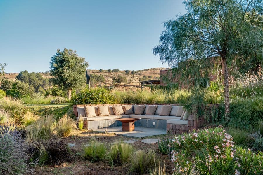 Vue panoramique du salon extérieur encaissé et du jardin au Domaine Eladâr